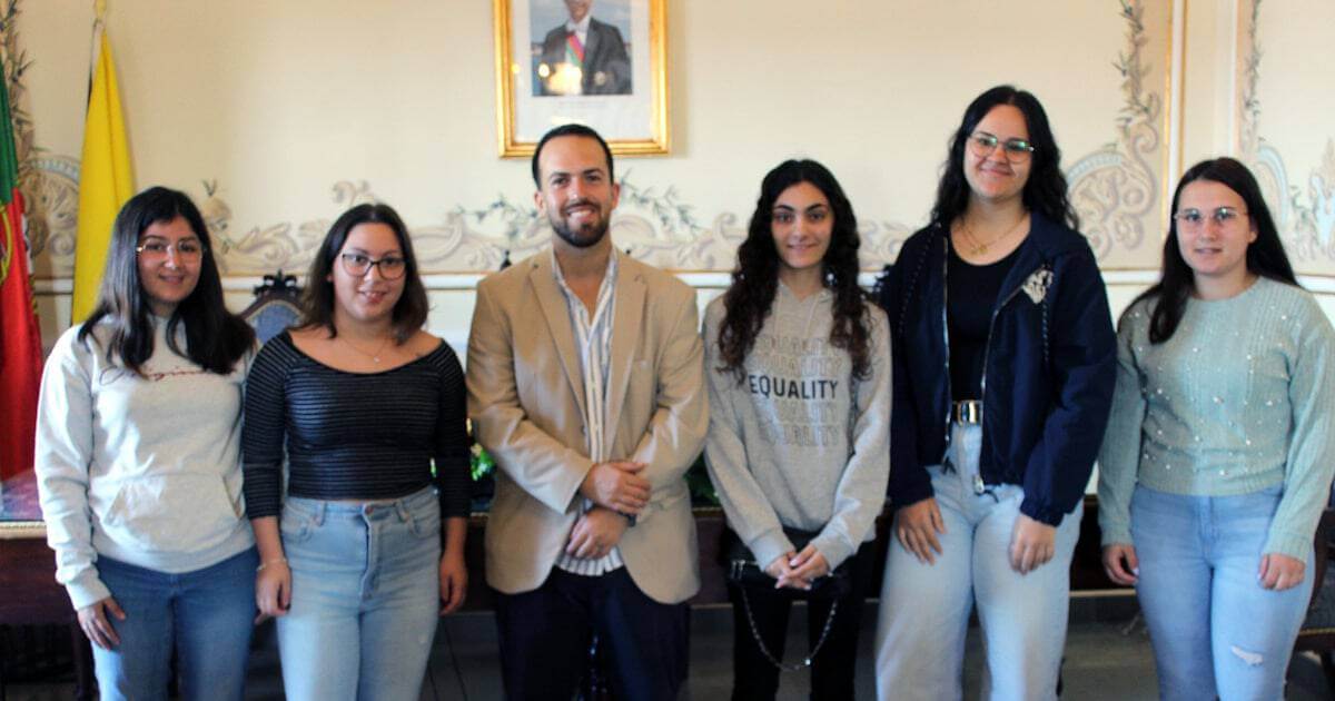 Grupo de jovens posando para foto em ambiente interno.